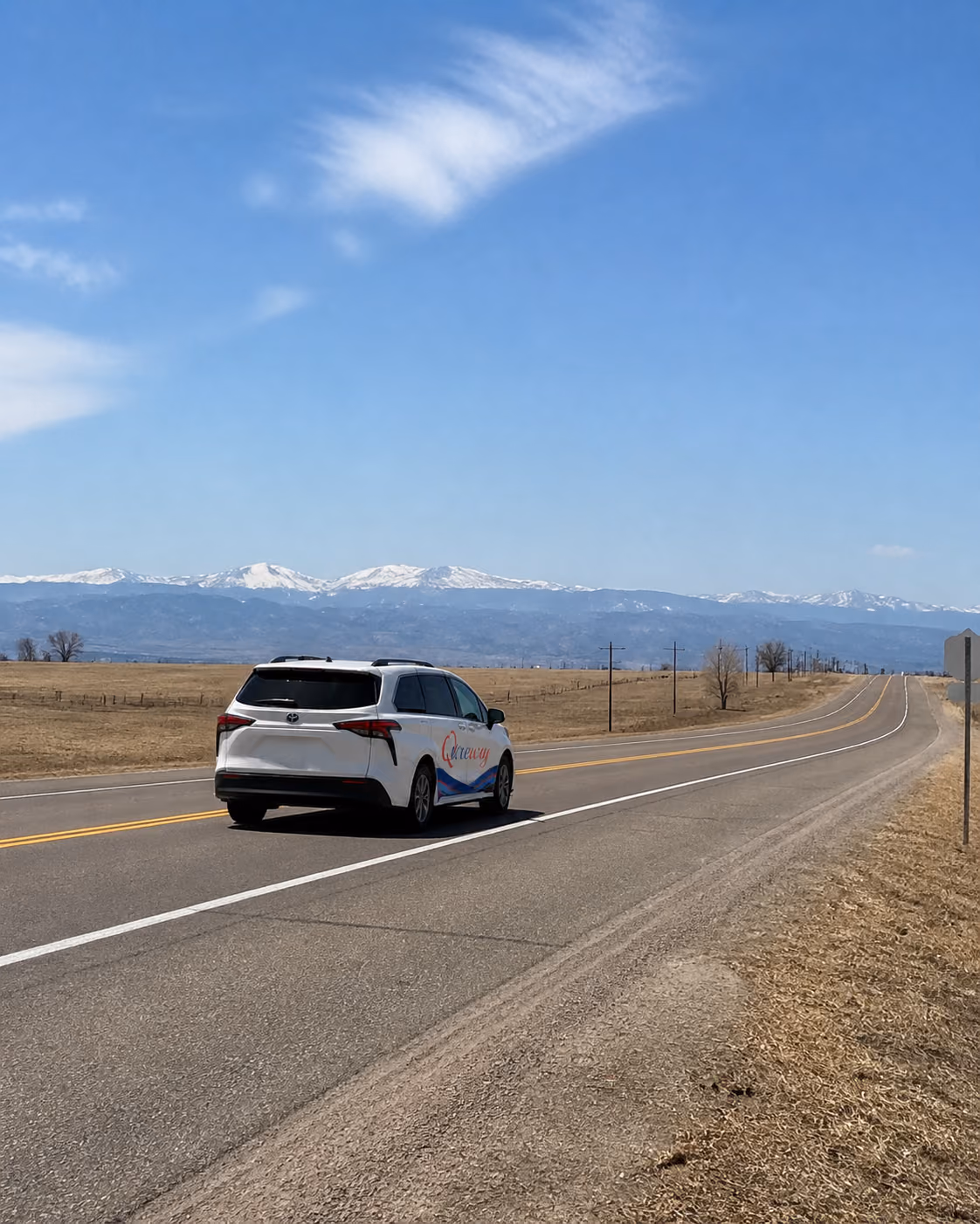 A Qureway wheelchair-accessible van traveling on a Colorado highway toward the mountains