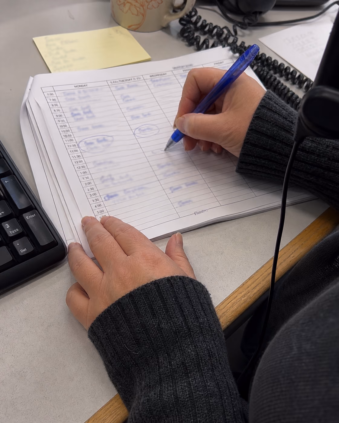 Hands reviewing a weekly ride schedule and marking a recurring appointment